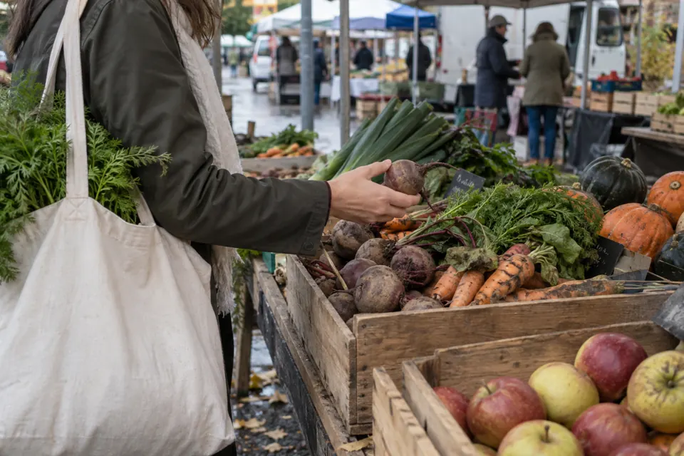 Seasonal vegetables and fruit in uneven crates at a neighborhood market.